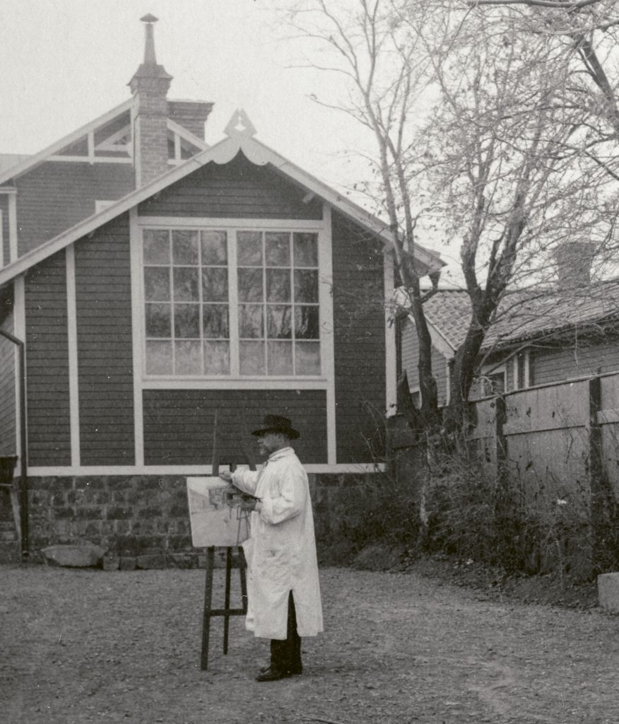Carl Larsson med auktionens akvarell ”Jag på gården i Falun” på staffliet utanför Skolhushållet på Blindgatan 48, Falun. 
<br>Foto: Carl Larsson-gårdens bildarkiv. 